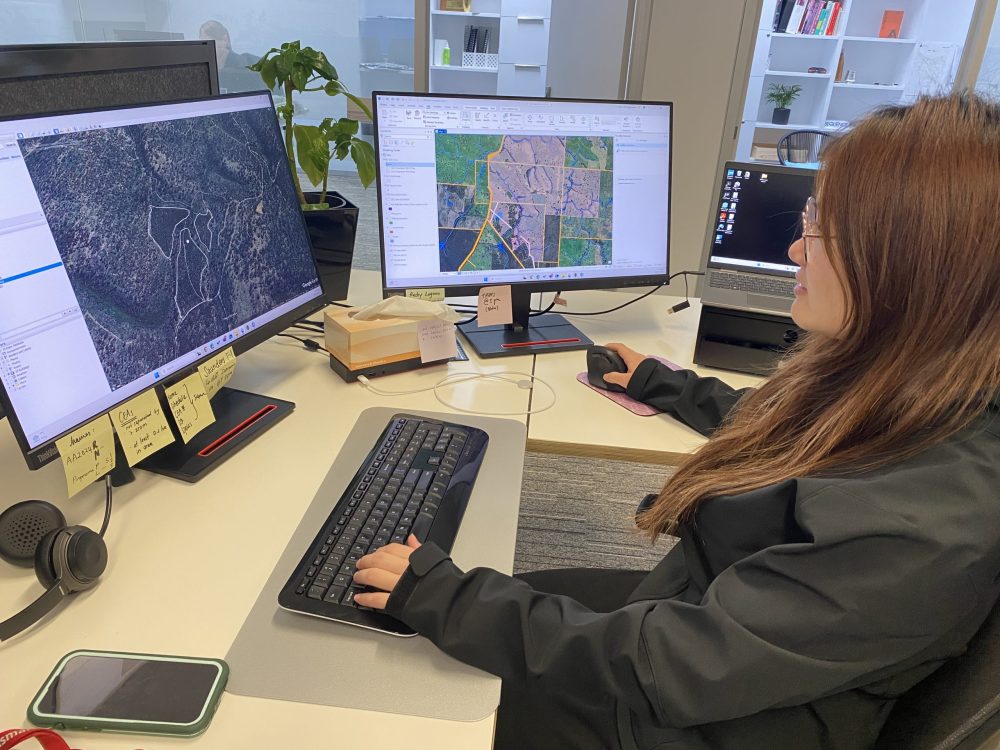 SFM staff member reviewing rural property maps on desktop monitors