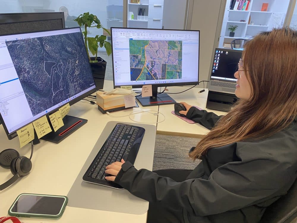 SFM staff member reviewing rural property maps on desktop monitors