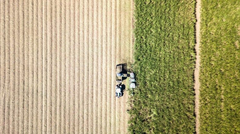 Aerial view of a harvester working across farmland